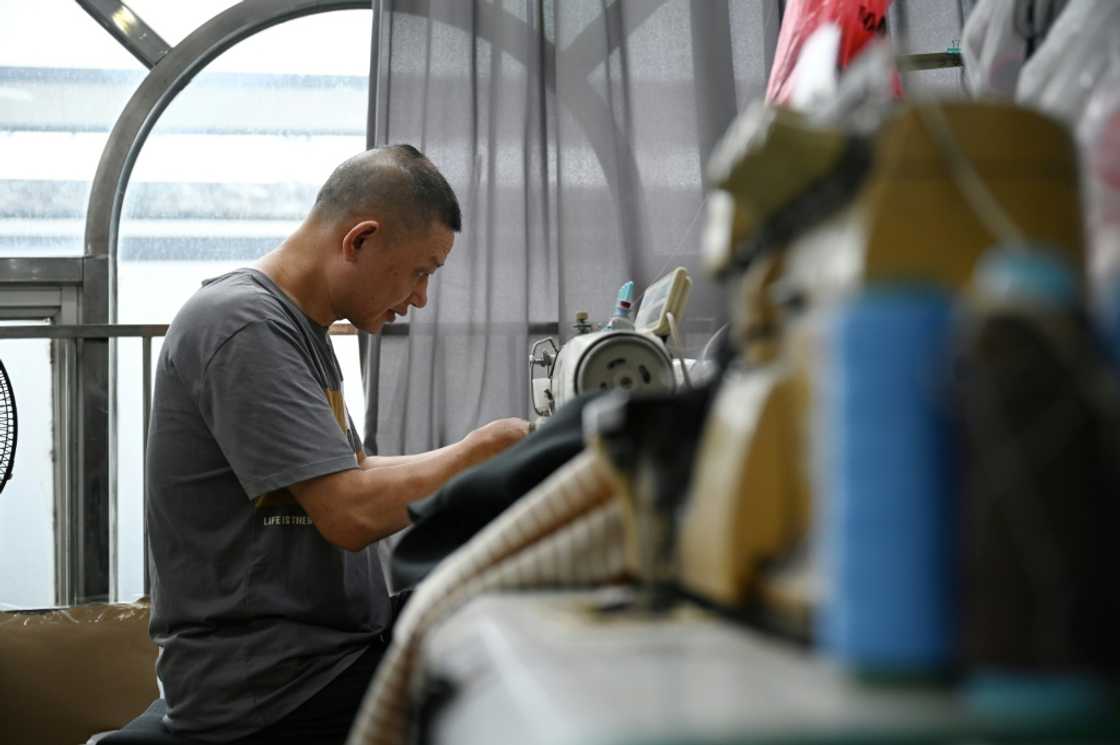 A worker sews clothing at the workshop of Amanda Yao, who is fighting to promote confidence in plus-size women