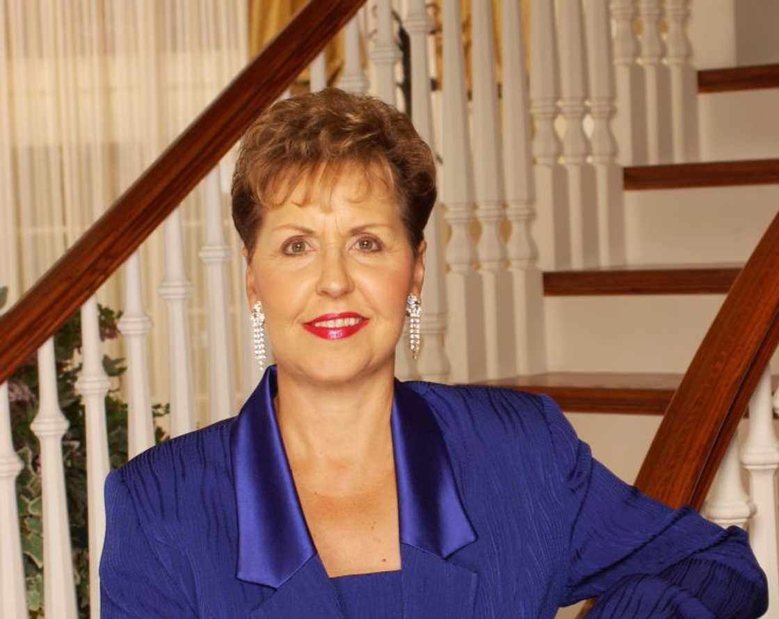 Joyce Meyer poses for a portrait in a blue outfit infront of the stairs