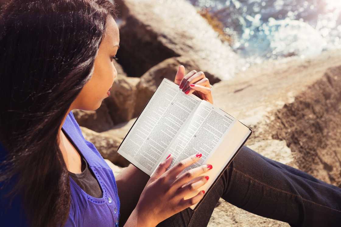 Young girl studying her bible outdoors