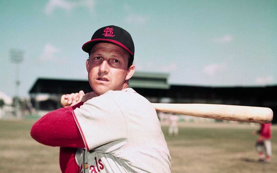 Stan Musial poses with a baseball bat