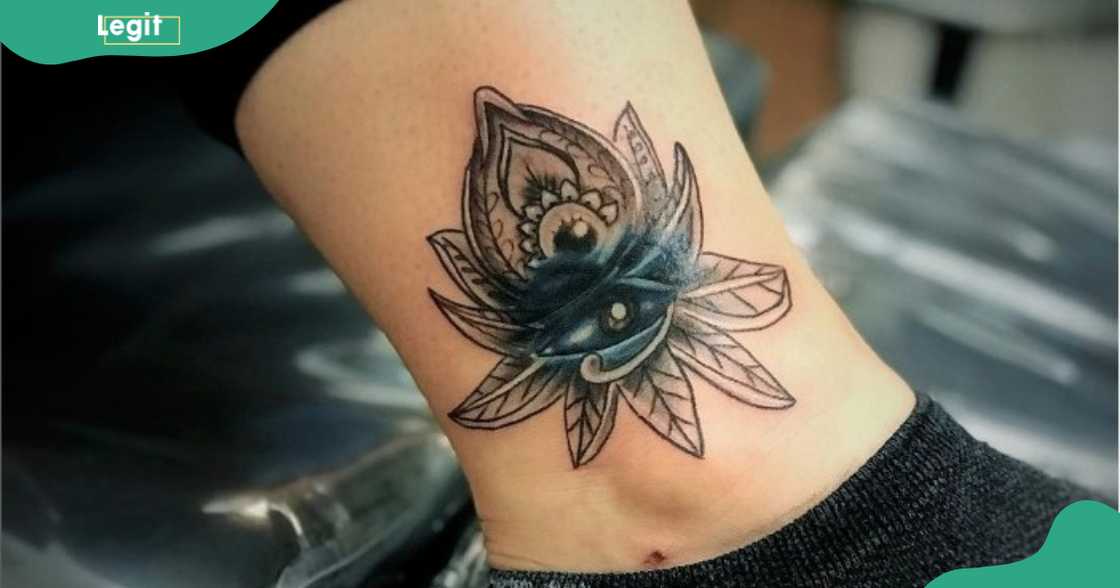 An Eye of Horus tattoo with a lotus flower.