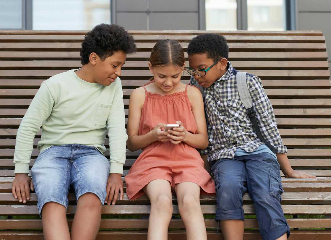 Kids looking at a smartphone together