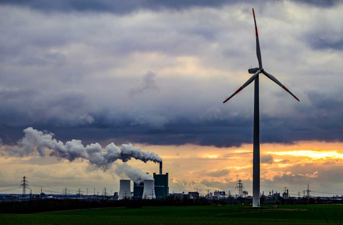 A wind turbine is seen in front of the lignite-fuelled Schkopau power plant south of Halle, Germany