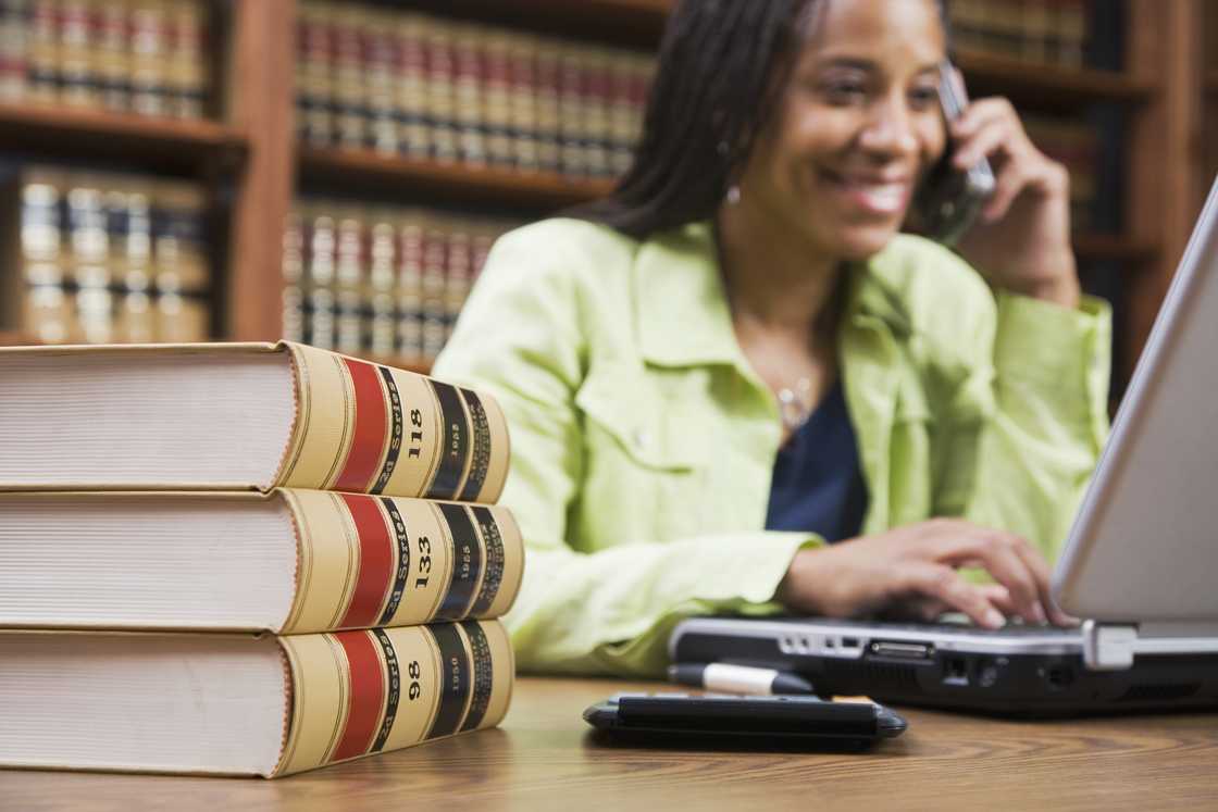 A lady using a computer while talking on a phone