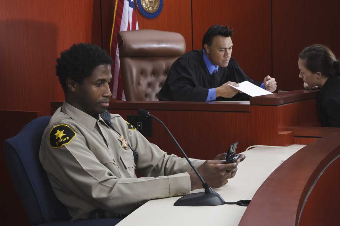 A security officer seated a desk in a court room