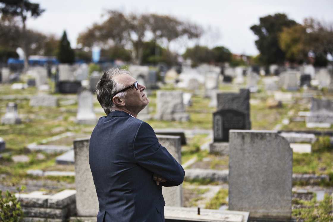 A man standing at a cemetery