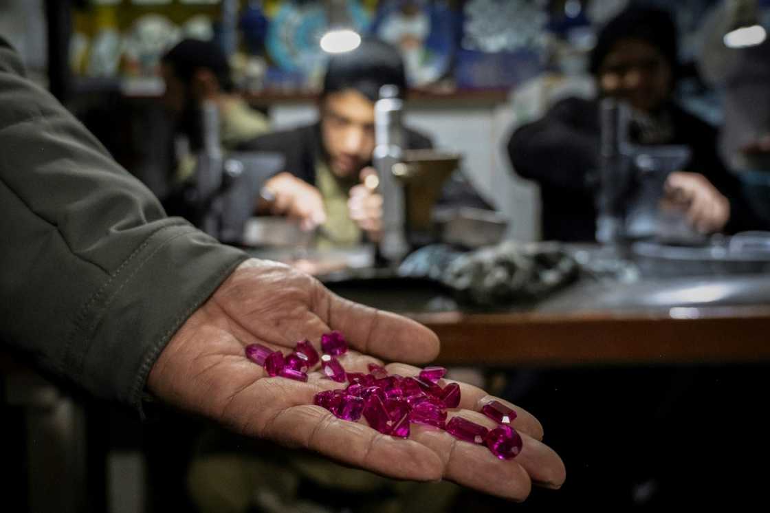 An Afghan jeweller displaying polished ruby gemstones at an engraving and goldsmith workshop in Kabul