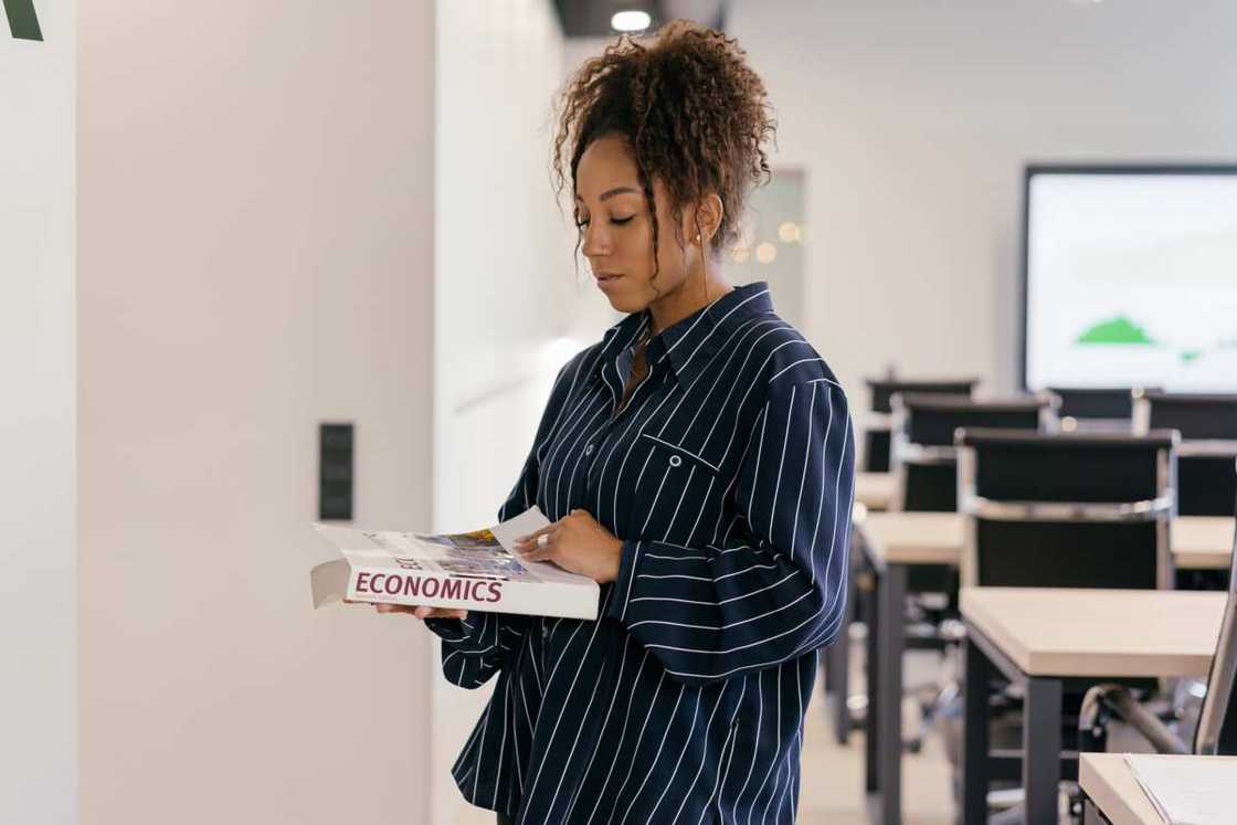 A student holding economics course book