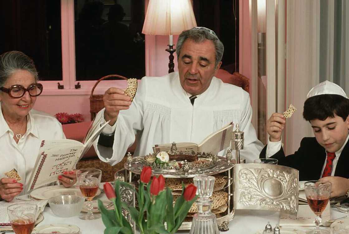 A Jewish family reads from the Haggadah as they celebrate Seder